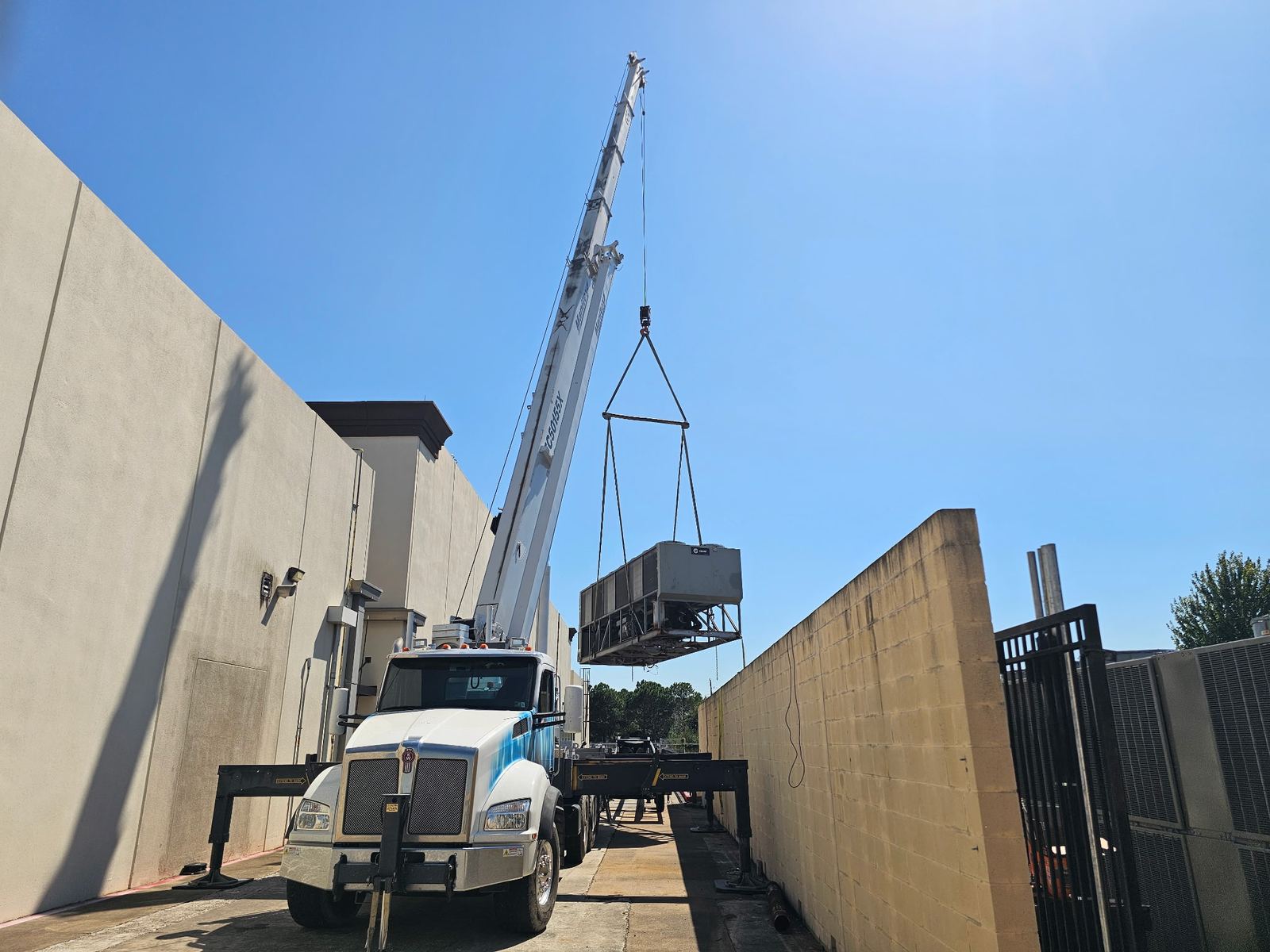 Crane lifting a new rooftop unit into place