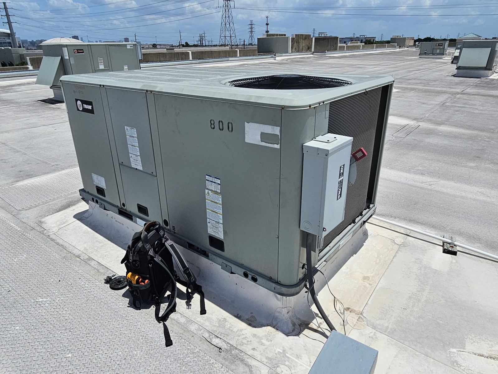 Technician tool bag at a rooftop unit during a maintenance visit